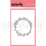 A single metal die cutout shown on a branded card. The die is a circular wreath-like border with leafy vines in a light gray/silver tone.