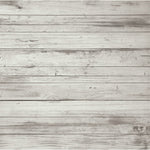 A close-up texture of horizontal whitewashed wooden planks with visible grain, knots, and weathered gray tones.